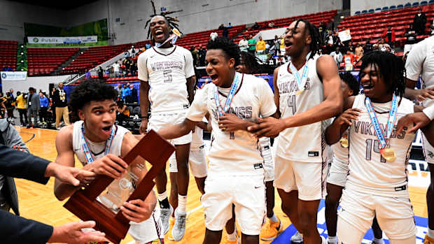Miami Norland players celebrate after receving the Class 5A state championship basketball trophy on Friday after beating Tampa Blake for the title at the RP Funding Center.